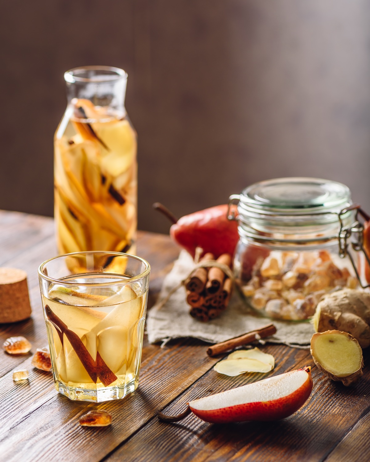 glasses and pitcher with mocktail and cocktail ingredients on wooden background