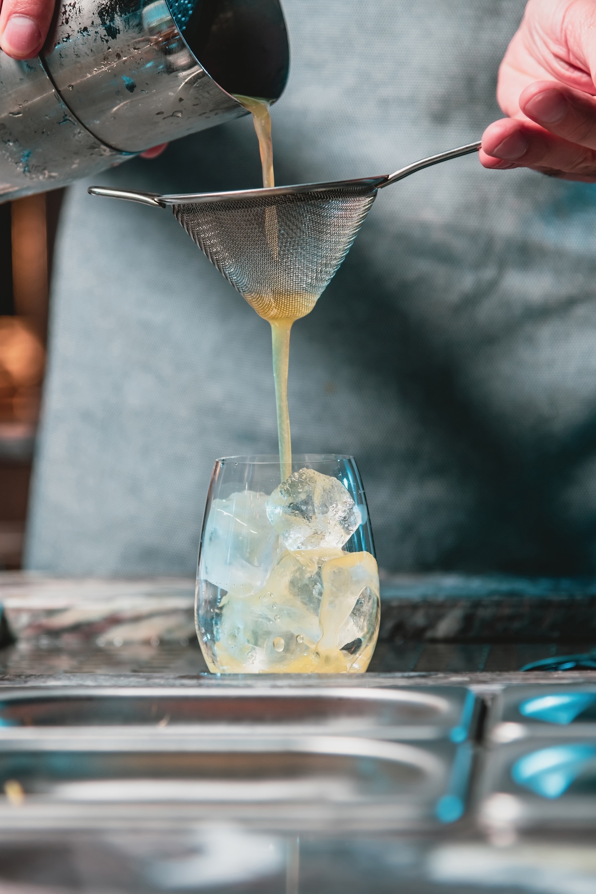 Bartender at nightclub preparing cocktails with bar equipment