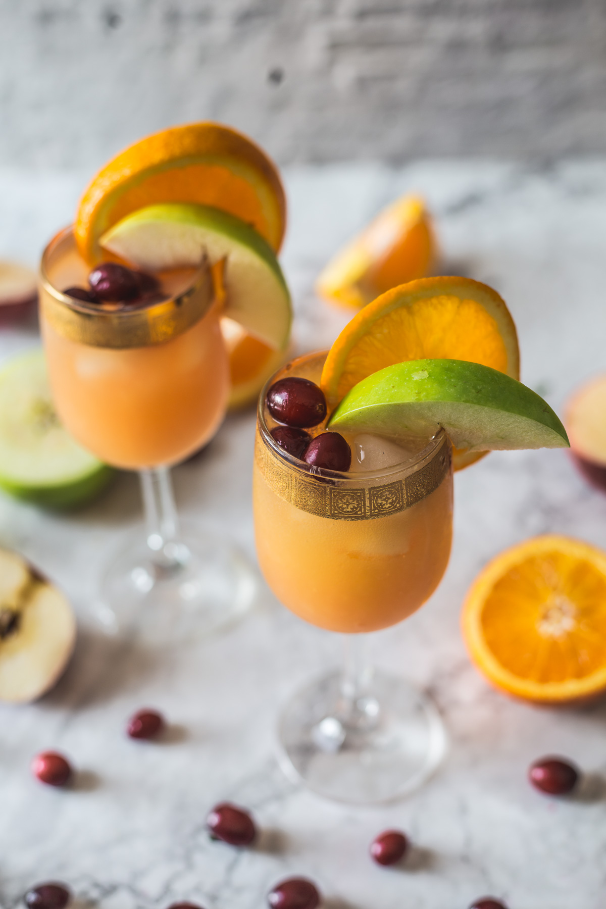 close up on two glasses with orange cranberry sangria mocktail
