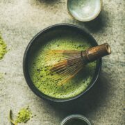 bowl of matcha tea with whisk.