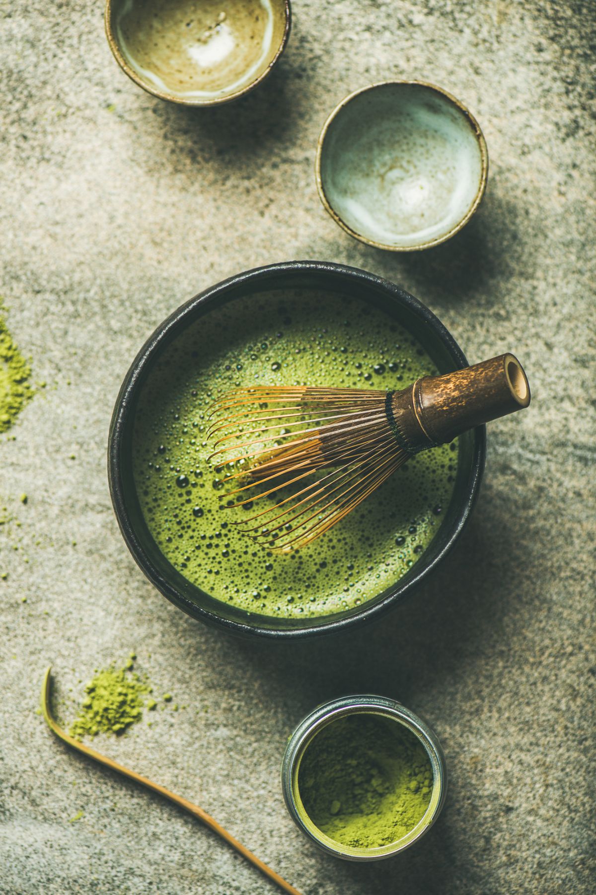 bowl of matcha tea with whisk.