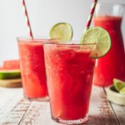 Two glasses of lime watermelon juice with straws.